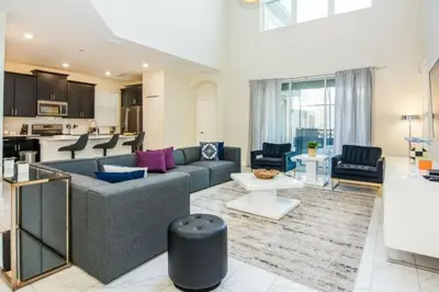 a living room with a couch and a kitchen at Gorgeous 5 Beds Home with Game Room and Pool in Kissimmee