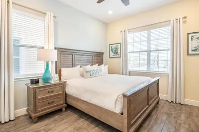 a bedroom with a bed and two windows at 3 Story Cottage With Private Pool Near Disney With Margaritaville Resort & Island H20 Access - 8105Su in Orlando