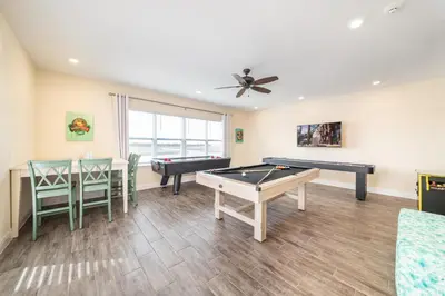 a living room with two ping pong tables and chairs at 3 Story Cottage With Private Pool Near Disney With Margaritaville Resort & Island H20 Access - 8105Su in Orlando