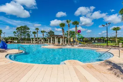 a swimming pool at a resort with palm trees at Our Mickey Mouse House Townhome with Pool! in Orlando
