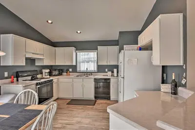 a kitchen with white appliances and a table with chairs at 7 Mi to WDW Indian Ridge Home with Pool Access! in Orlando
