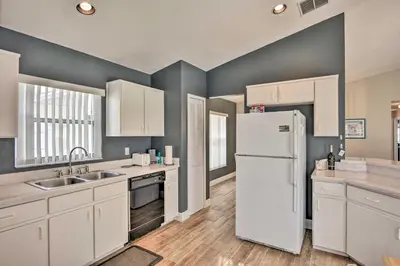 a kitchen with white cabinets and a white refrigerator at 7 Mi to WDW Indian Ridge Home with Pool Access! in Orlando