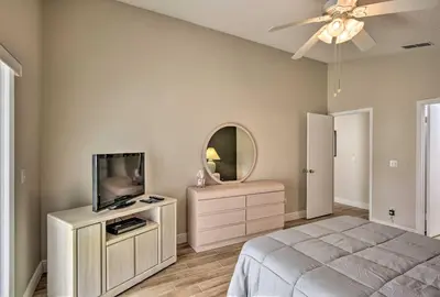 a bedroom with a bed and a tv and a mirror at 7 Mi to WDW Indian Ridge Home with Pool Access! in Orlando