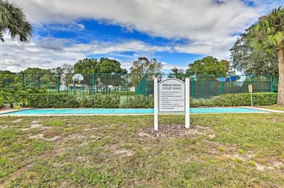 a sign in the grass in front of a tennis court at 7 Mi to WDW Indian Ridge Home with Pool Access! in Orlando