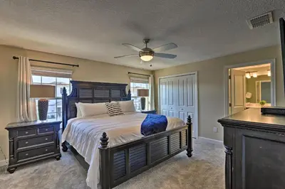 a bedroom with a bed and a ceiling fan at about 6 Mi to Disney Kissimmee Retreat with Pool! in Kissimmee