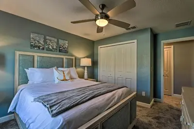 a bedroom with a bed with a ceiling fan at about 6 Mi to Disney Kissimmee Retreat with Pool! in Kissimmee
