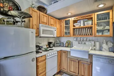 a kitchen with wooden cabinets and a white refrigerator at Lake Marion Apt with Canoe in Altamonte Springs! in Orlando