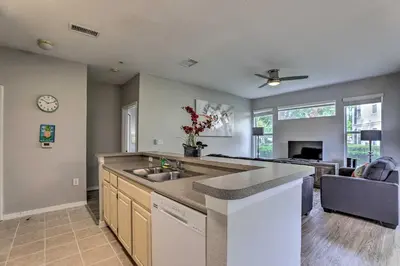 a kitchen with a sink and a living room at Lake-View Condo with Pool Access 6 Mi to Disney! in Kissimmee