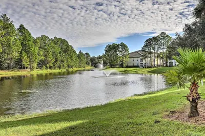 a pond in front of a house with a fountain at Lake-View Condo with Pool Access 6 Mi to Disney! in Kissimmee