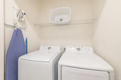 a laundry room with two machines and a towel at Charming Cottage 3 Miles From Disney With Margaritaville Resort & Island H2O Access - 8083Kd in Orlando