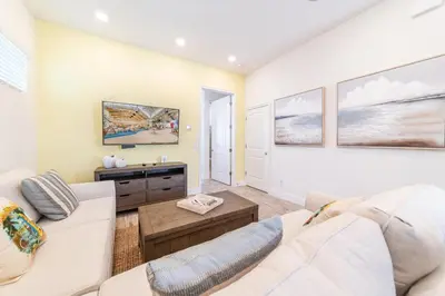 a living room with a couch and a table at Charming Cottage 3 Miles From Disney With Margaritaville Resort & Island H2O Access - 8083Kd in Orlando