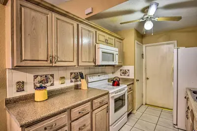 a kitchen with wooden cabinets and a white refrigerator at Kissimmee Home 5 Mi to Gatorland and 15 Mi to Disney in Kissimmee