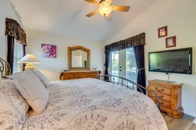 a bedroom with a bed and a flat screen tv at 12 Mi to Disney Home with Pool and Spa in Clermont in Orlando