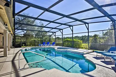 an indoor swimming pool with a glass roof at 12 Mi to Disney Home with Pool and Spa in Clermont in Orlando