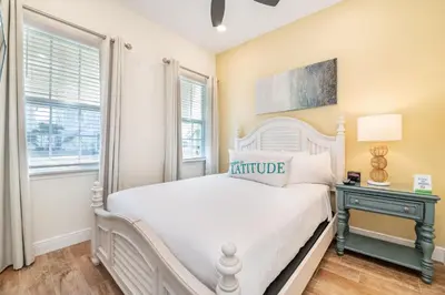 a bedroom with a white bed and two windows at Darling Five Bedroom Cottage Near Disney With Margaritaville Resort & Island H20 Waterpark Access - 2974La in Orlando