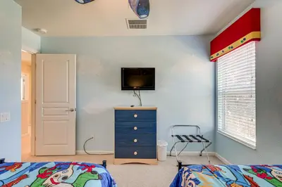 a bedroom with a bed and a tv on a wall at 3 Mi to WDW Windsor Hills Home with Game Room! in Orlando
