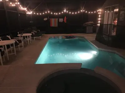 a swimming pool in a room with lights and tables at 7 Bedroom, 6 bath and pool near Disney in Emerald Island 4 King Master Suites in Kissimmee
