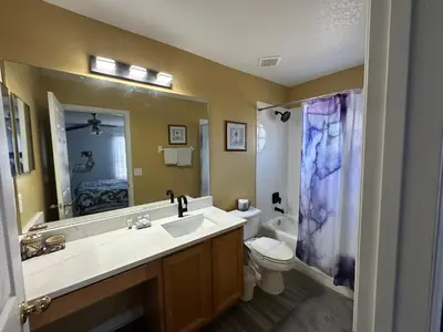 a bathroom with a sink and a toilet and a mirror at 7 Bedroom, 6 bath and pool near Disney in Emerald Island 4 King Master Suites in Kissimmee