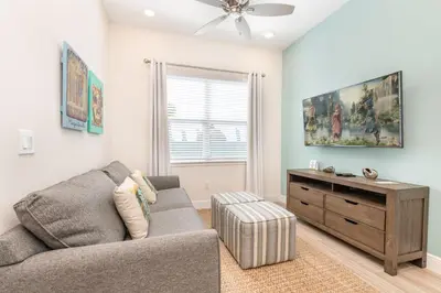 a living room with a couch and a dresser at Blue Cascade Cottage Near Disney With Margaritaville Resort & Island H2O Access - 8064Ls in Orlando
