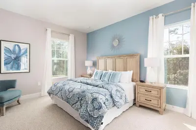 a bedroom with a bed and a blue wall at 5min Disney Wonderful Villa, BBQ, SMV102 in Orlando