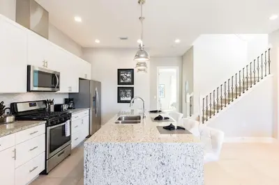 a kitchen with white cabinets and a counter top at 5min Disney Wonderful Villa, BBQ, SMV102 in Orlando