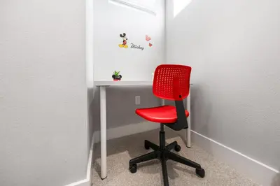 a red chair sitting in front of a desk at 5min Disney Cozy Villa, BBQ Grill, SMV108 in Orlando