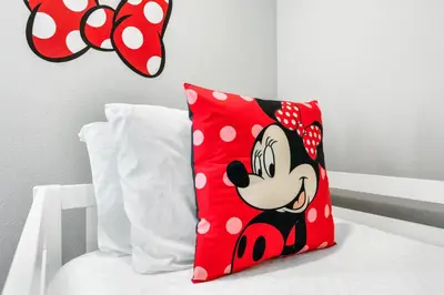 a red pillow with a mickey mouse on a bed at 5min Disney Cozy Villa, BBQ Grill, SMV108 in Orlando