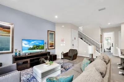 a living room with a couch and a tv at 5 BR 6 BA Luxury Villa 5 min to Disneyworld Hot Tub & BBQ 112 in Orlando