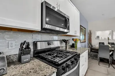 a kitchen with a stove and a tv above it at 5 BR 6 BA Luxury Villa 5 min to Disneyworld Hot Tub & BBQ 112 in Orlando