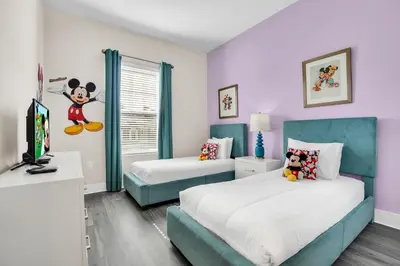 a bedroom with two beds and a tv in it at 5 BR 6 BA Luxury Villa 5 min to Disneyworld Hot Tub & BBQ 112 in Orlando