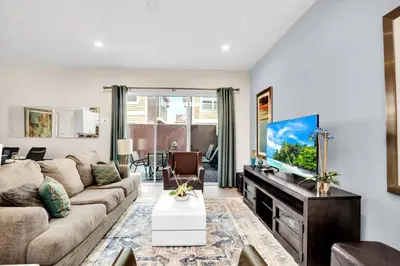 a living room with a couch and a tv at 5 BR 6 BA Luxury Villa 5 min to Disneyworld Hot Tub & BBQ 112 in Orlando