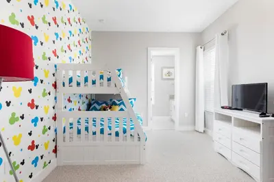 a bedroom with a white crib and a wall covered in colorful footprints at 5min Disney Fantastic Family Villa SMV113 in Orlando