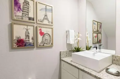 a bathroom with a sink and pictures on the wall at 5min Disney Fantastic Family Villa SMV113 in Orlando