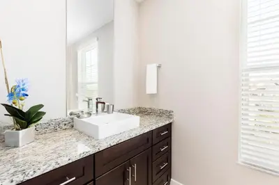 a bathroom with a sink and a mirror at 5min Disney Fantastic Townhome, BBQ 116 in Orlando