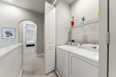 a white laundry room with a washer and dryer at Ultra convenient stay, 5 min to Disney SMV118 in Orlando