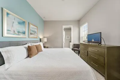a bedroom with a bed and a dresser with a television at Ultra convenient stay, 5 min to Disney SMV118 in Orlando