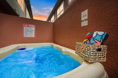 a hot tub with blue water in the corner of a building at Comfy Villa 5 Min to Dinsey! Hot Tub & BBQ in Orlando