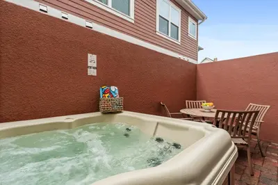 a jacuzzi tub in a patio with a table at Comfy Villa 5 Min to Dinsey! Hot Tub & BBQ in Orlando