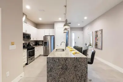 a kitchen with a granite counter top and appliances at Amazing Family Villa 5min Disney w BBQ 128 in Orlando