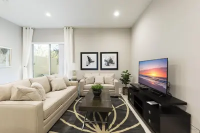 a living room with a white couch and a flat screen tv at 5min Disney Lovely Villa Hot tub 130 in Orlando