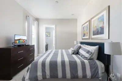 a bedroom with a bed and a dresser with a television at 5min Disney Lovely Villa Hot tub 130 in Orlando