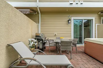 a patio with a table and chairs next to a building at 5min Disney Lovely Villa Hot tub 130 in Orlando