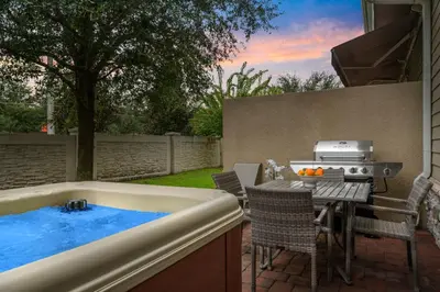 a backyard with a hot tub and a table and chairs at 5min Disney Lovely Villa Hot tub 130 in Orlando