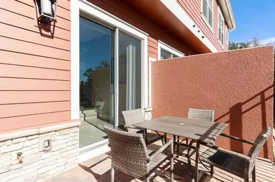 a table and chairs on a patio with a window at Fantastic Townhome 5min Disneyworld 134 in Orlando