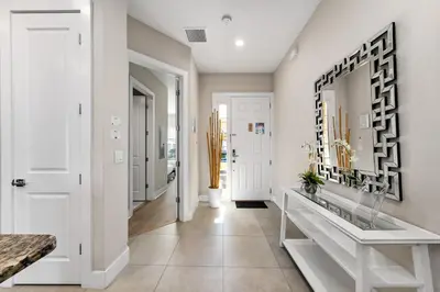 a hallway with white walls and a white console table at 5min to Disney Spacious Family Villa SMV135 in Orlando