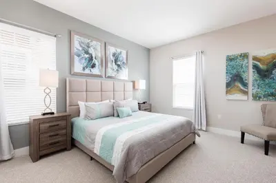 a bedroom with a large bed and a chair at Beautiful Family Villa Patio area with BBQ 5min Disney in Orlando
