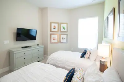 a bedroom with two beds and a flat screen tv at Amazing Family Villa, 5min Disney SMV144 in Orlando
