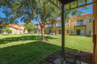 a view of a building with a tree in the yard at Emerald Island-RU1029 in Kissimmee