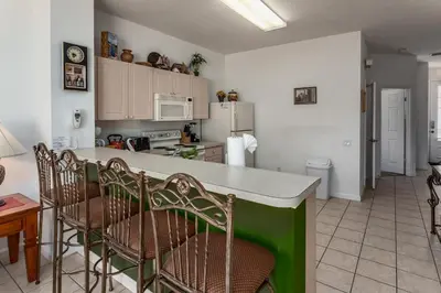a kitchen with a counter and chairs in a room at Windsor Palms-RU831 in Kissimmee