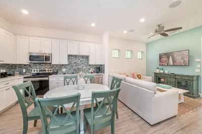 a kitchen and living room with a table and chairs at Sea Breeze Cottage Near Disney With Margaritaville Resort & Island H20 Waterpark Access - 2982La in Orlando
